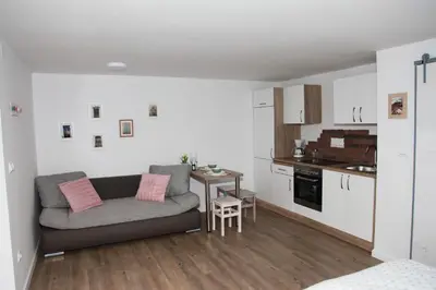 a living room with a couch and a table with pink pillows at STUDIO LUNA in Bled