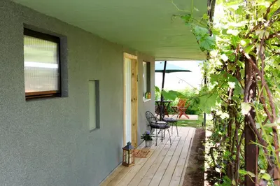 a porch of a house with a table and chairs at STUDIO LUNA in Bled