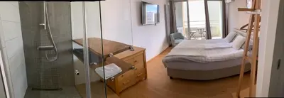 a bathroom with a shower and a small bed in a room at Mr and Mrs Bright 5 in Ljubljana
