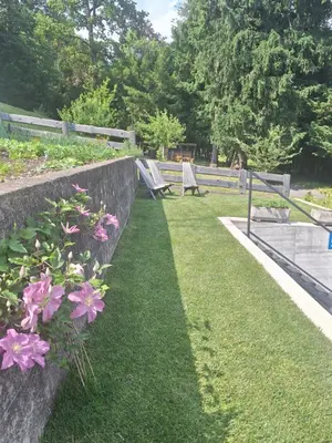 a park with benches and pink flowers in the grass at Apartma Arnež in Bled