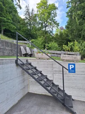 a metal staircase with a parking sign in a park at Apartma Arnež in Bled