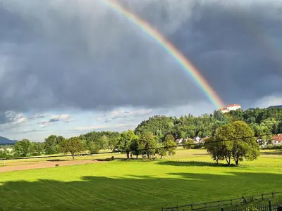 a rainbow in the sky over a green field at Apartma Arnež in Bled