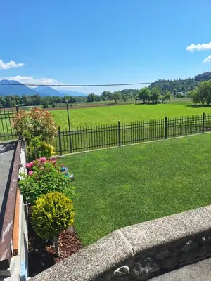 a garden with flowers and a fence and a field at Apartma Arnež in Bled