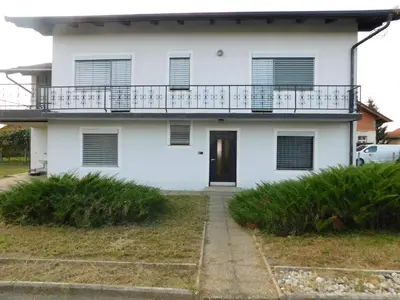 a white house with a balcony and a door at Haus Videm in Videm pri Ptuju