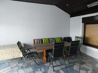 a room with a table and chairs and a bench at Haus Videm in Videm pri Ptuju