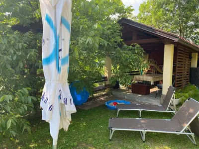 a yard with two chairs and a umbrella at Apartma Leban Most na Soči in Most na Soči