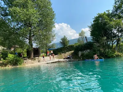 a group of people on the shore of a lake at Apartma Leban Most na Soči in Most na Soči