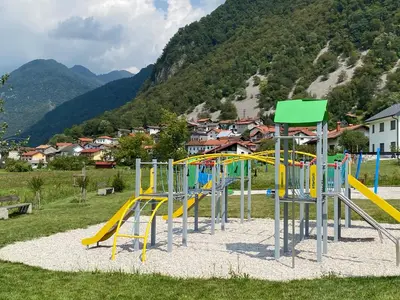 a playground with a bunch of slides in a field at Apartma Leban Most na Soči in Most na Soči