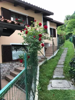 a fence with red roses on a house at Apartma Leban Most na Soči in Most na Soči