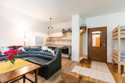 a living room with a leather couch and a table at Apartment Life in Bled