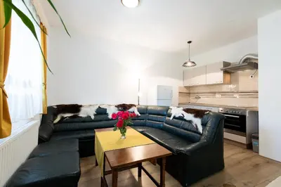 a living room with a black leather couch and a table at Apartment Life in Bled