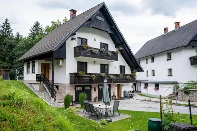 a large white house with a table and chairs at Brane & Jaka Apartments in Bohinj