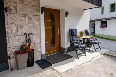 a patio with a table and chairs next to a door at Brane & Jaka Apartments in Bohinj