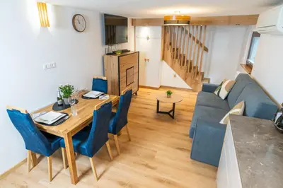 a living room with a table and a blue couch at Brane & Jaka Apartments in Bohinj
