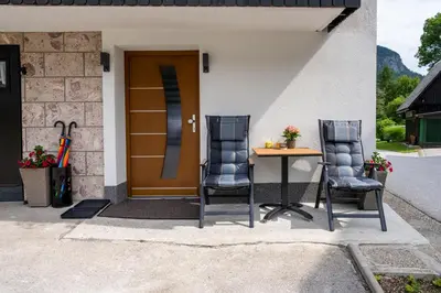 two chairs and a table in front of a house at Brane & Jaka Apartments in Bohinj