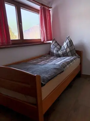 a small bed in a room with a window at Apartments Kamp Podgrad Vransko in Vransko