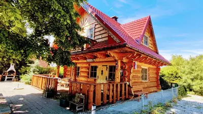 a wooden house with a red roof at Vila Vilinka & Vila Native Vilinija resort Village in Podčetrtek
