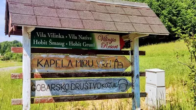 a sign in a field with some writing on it at Vila Vilinka & Vila Native Vilinija resort Village in Podčetrtek