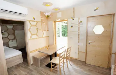 a room with a table and a bed and a door at Honey Paradise glamping resort in Dobova