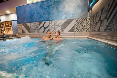 two men in a jacuzzi in a hot tub at Honey Paradise glamping resort in Dobova