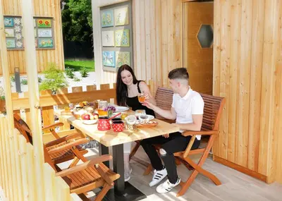 a man and a woman sitting at a table at Honey Paradise glamping resort in Dobova