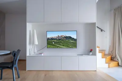 a living room with a tv on a white wall at Suites DANICA in Šmartno