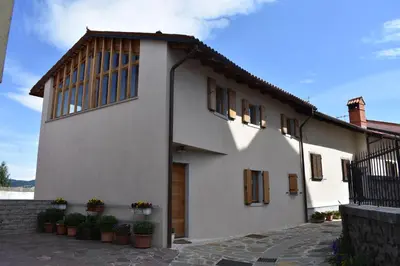 a white house with potted plants in front of it at Suites DANICA in Šmartno