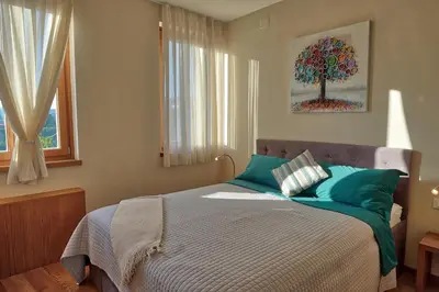 a bedroom with a bed with a tree on the wall at Suites DANICA in Šmartno