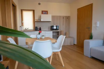 a living room with a table and chairs and a kitchen at Suites DANICA in Šmartno