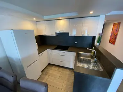 a small kitchen with white cabinets and a refrigerator at Castle View in Tolmin