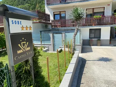 a sign in front of a building with a house at Castle View in Tolmin