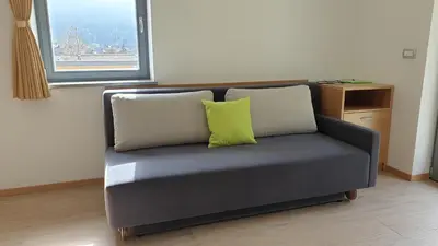 a couch with two pillows on it in a room at Apartments Vila Darja in Bohinj