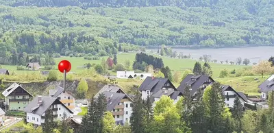 a village with a red balloon in the mountains at Apartments Vila Darja in Bohinj