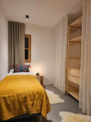 a bedroom with a yellow bed and a closet at Apartmaji štAla in Kranjska Gora