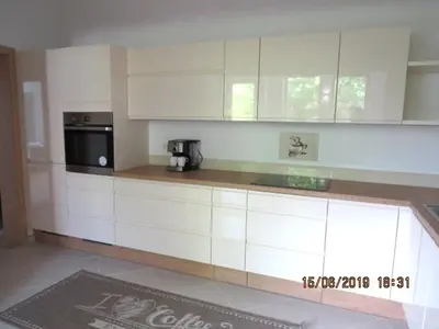 a kitchen with white cabinets and a black microwave at Sunlight Apartment in Bled