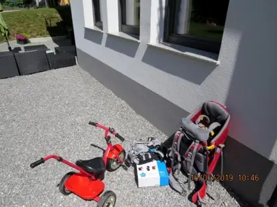 a small red scooter parked next to a building at Sunlight Apartment in Bled