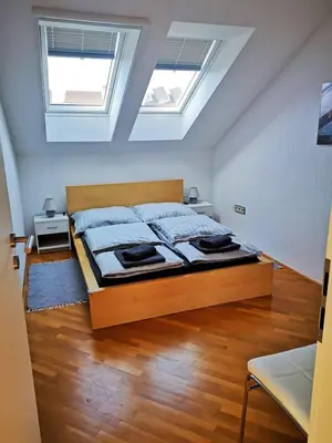 a bedroom with a large bed with a skylight at Ela's Apartment in Komenda