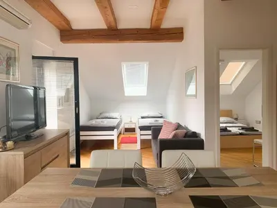 a living room with a television and a living room with a bed at Ela's Apartment in Komenda