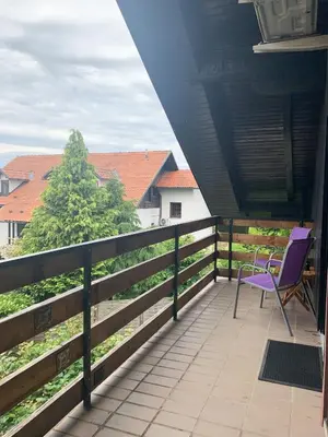 a purple chair sitting on the balcony of a house at Ela's Apartment in Komenda