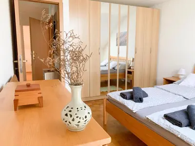 a white vase sitting on a table in a bedroom at Ela's Apartment in Komenda