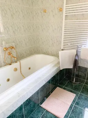 a bathroom with a bath tub and a sink at Ela's Apartment in Komenda