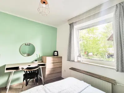 a bedroom with a desk and a bed and a window at Deerwood Holiday Cozy Retreat 2br Apartment with Stunning Castle Views in Bled