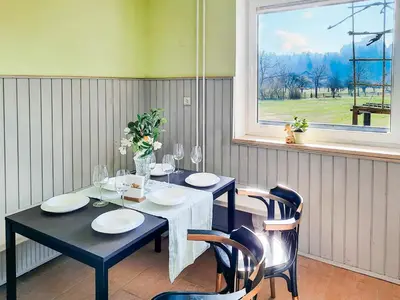 a dining room with a table and chairs and a window at Deerwood Holiday Cozy Retreat 2br Apartment with Stunning Castle Views in Bled