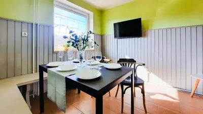 a dining room with a table with a vase of flowers at Deerwood Holiday Cozy Retreat 2br Apartment with Stunning Castle Views in Bled