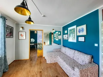 a living room with a couch and a blue wall at Deerwood Holiday Cozy Retreat 2br Apartment with Stunning Castle Views in Bled