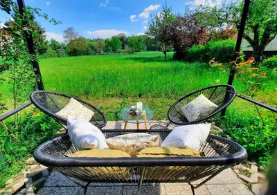 a table and chairs with pillows on a patio at Deerwood Holiday Cozy Retreat 2br Apartment with Stunning Castle Views in Bled