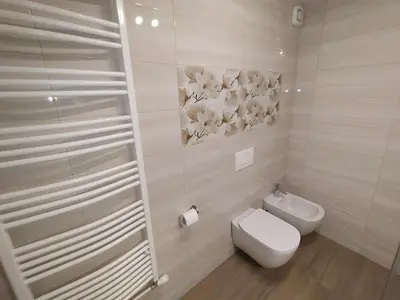a white bathroom with a toilet and a sink at Apartmaji Maln in Dolenjske Toplice