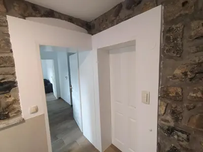 a room with white walls and a stone wall at Apartmaji Maln in Dolenjske Toplice