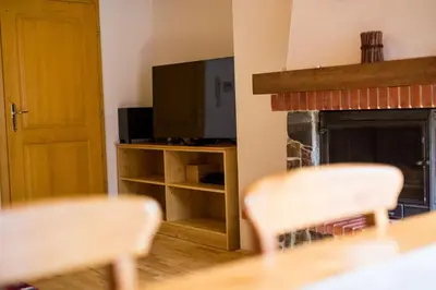 a living room with two chairs and a fireplace at Bolfenk lodge apartment in Pohorje