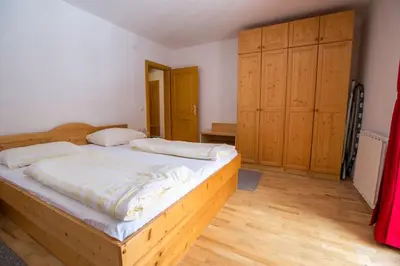 a bedroom with a wooden bed and wooden cabinets at Bolfenk lodge apartment in Pohorje